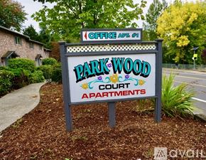 Portland apartment for rent - A sign for Park Wood Court Apartments is displayed in front of a building.