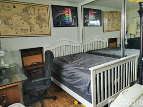 Laguna Woods condo for rent - A bedroom with a white bed and a chair.