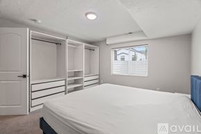 Lehi apartment for rent - A bedroom with a bed, a window with blinds, and a closet with shelves.