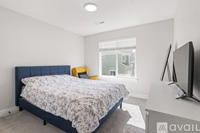 Lehi apartment for rent - A bedroom with a bed, a television, and a window.