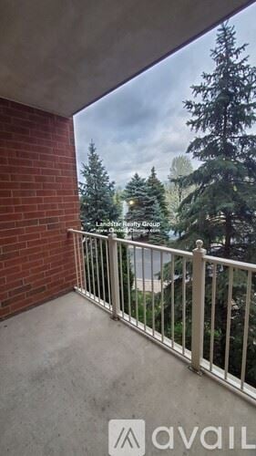 Itasca apartment for rent - A balcony with a metal railing and a view of trees.