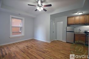 Chicago apartment for rent - A room with a ceiling fan and wooden flooring.