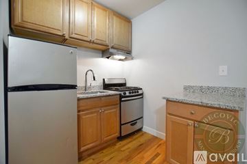 Chicago apartment for rent - A kitchen with wooden cabinets and a white refrigerator.