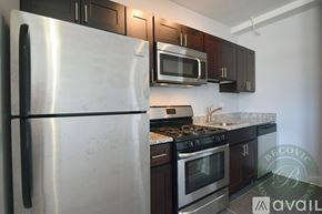 Chicago apartment for rent - A kitchen with a stainless steel refrigerator, microwave, and oven.