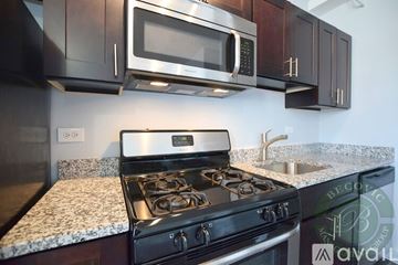 Chicago apartment for rent - A modern kitchen with a black stove and microwave above it.
