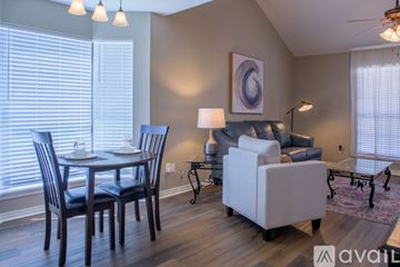 Shreveport townhouse for rent - A living room with a dining table and chairs.