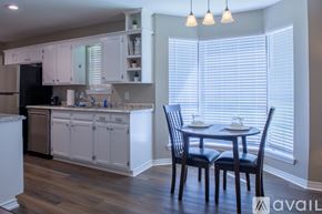 Shreveport townhouse for rent - A kitchen with a table and chairs in front of a window.