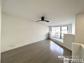 Chicago apartment for rent - A spacious room with a ceiling fan and a window letting in natural light.
