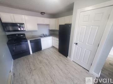 La Crosse apartment for rent - A kitchen with black appliances and white cabinets.