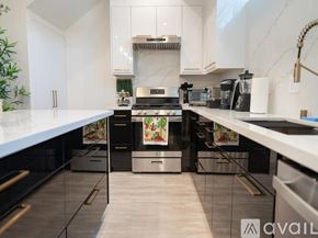 Los Angeles house for rent - A modern kitchen with white cabinets and stainless steel appliances.