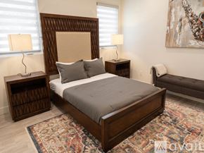 Los Angeles house for rent - A bedroom with a large bed and a painting on the wall.