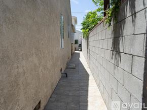 Los Angeles house for rent - A narrow alley with a wall on one side and a building on the other.