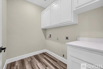 Sherman house for rent - A kitchen with white cabinets and a wooden floor.