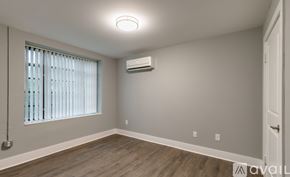 Highland Park apartment for rent - A room with a window, wooden floor, and an air conditioner.