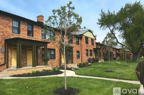 Detroit apartment for rent - A tree stands in front of a row of houses.