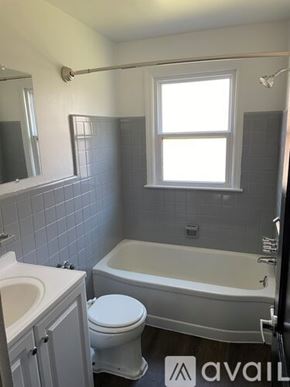 Detroit apartment for rent - A bathroom with a toilet, sink, and bathtub.