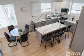 Los Angeles house for rent - A kitchen with a table and chairs in the middle of the room.