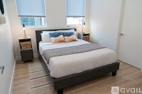 Los Angeles house for rent - A bedroom with a large bed and a wooden floor.
