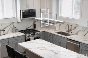 Los Angeles house for rent - A kitchen with a marble countertop and a stove top oven.