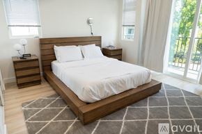 Los Angeles house for rent - A bedroom with a large bed and a nightstand with a lamp.