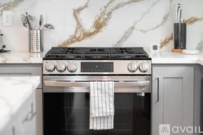 Los Angeles house for rent - A modern kitchen with a black stove top oven and a marble backsplash.