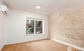 Chicago apartment for rent - A room with a window and a brick wall.