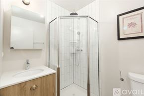 Chicago apartment for rent - A bathroom with a white sink and a glass shower stall.