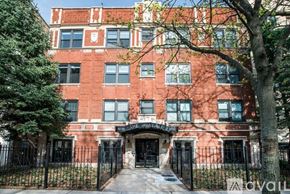 Chicago apartment for rent - A red brick building with a black gate in front.