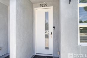 Los Angeles house for rent - A white door with a glass window and a black handle is on the front of a building.