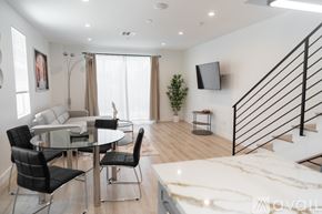 Los Angeles house for rent - A modern dining room with a glass table and chairs.