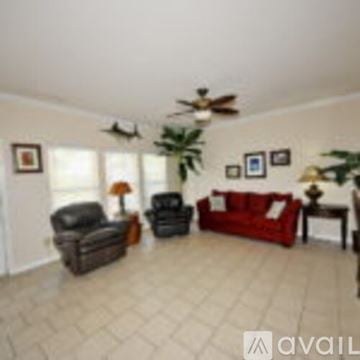 Corpus Christi condo for rent - A living room with a red couch and a ceiling fan.