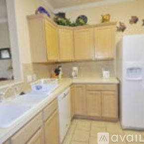 Corpus Christi condo for rent - A kitchen with wooden cabinets and a white fridge.