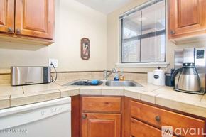 Tucson condo for rent - A kitchen with wooden cabinets and a white dishwasher.