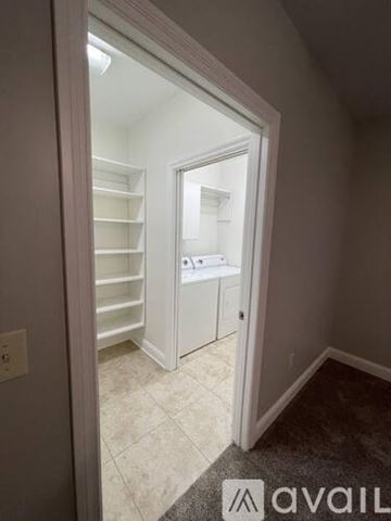 Marion apartment for rent - A white doorway opens to a kitchen with white cabinets and a tiled floor.