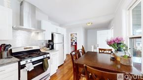 Somerville apartment for rent - A kitchen with white cabinets and a wooden table.