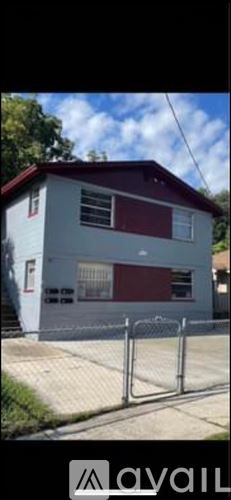 Jacksonville apartment for rent - A house with a red roof and a white fence.