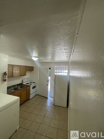 Jacksonville apartment for rent - A kitchen with wooden cabinets and a black stove top oven.
