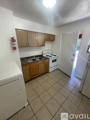Jacksonville apartment for rent - A kitchen with wooden cabinets and a black dishwasher.
