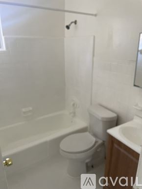 Jacksonville apartment for rent - A white toilet is next to a bathtub in a bathroom.