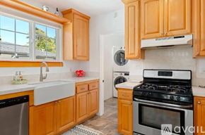 Santa Barbara house for rent - A kitchen with wooden cabinets and a black stove top oven.