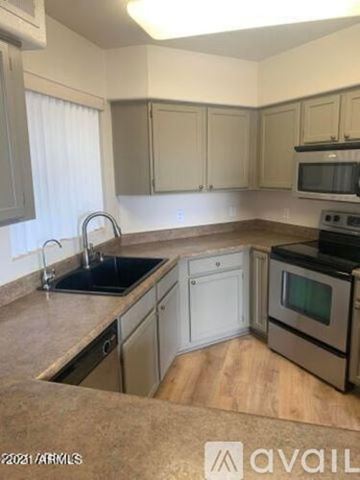 Phoenix apartment for rent - A kitchen with a sink, stove, and cabinets.