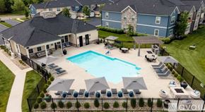 Sunbury apartment for rent - A large swimming pool surrounded by a black fence and lounge chairs.