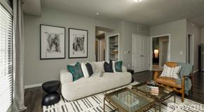 Sunbury apartment for rent - A living room with a white couch, a glass coffee table, and a striped rug.