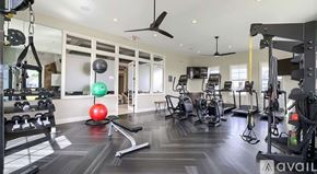 Sunbury apartment for rent - A gym with a variety of equipment including a bench, weights, and a fan.