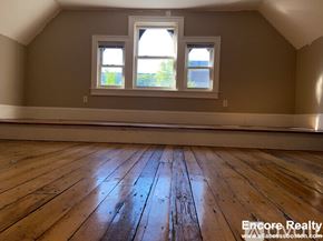 Boston apartment for rent - A room with wooden floors and two windows.