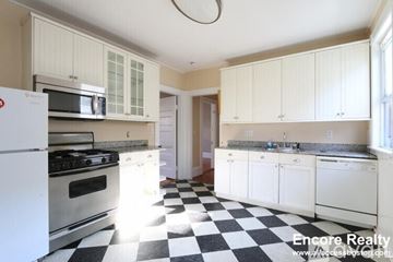 Boston apartment for rent - A kitchen with white appliances and black and white checkered floor.