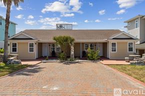 Fernandina Beach townhouse for rent - A house with a brick driveway and a palm tree in front.