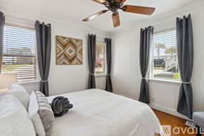 Fernandina Beach townhouse for rent - A bedroom with a large bed and a ceiling fan.