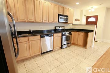 Brookline apartment for rent - A kitchen with wooden cabinets and black appliances.