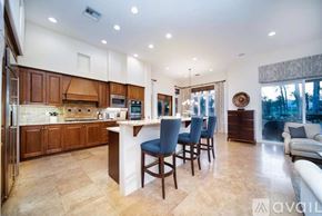 La Quinta house for rent - A kitchen with a bar and chairs in front of a window.